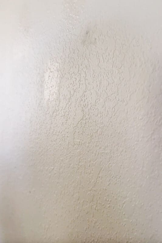 How to skim coat a wall: close-up of heavy orange peel texture before skim coating