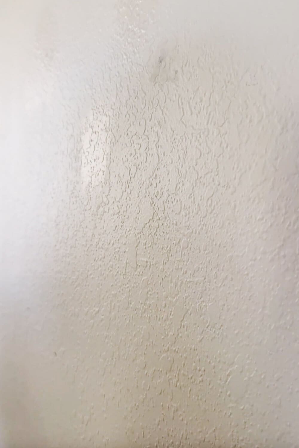 How to skim coat a wall: close-up of heavy orange peel texture before skim coating