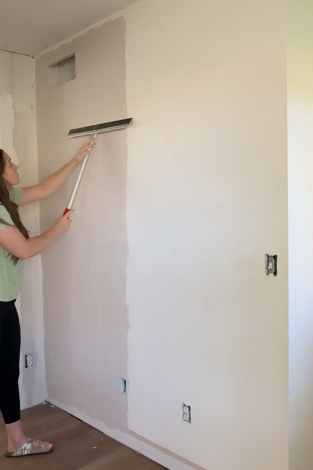 How to skim coat a wall: smoothing the rolled-on mud with a magic trowel for a flat, paint-ready finish