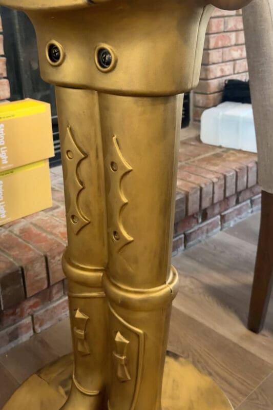 Close up of the legs on an antique bronze giant nutcracker, showing the smooth Rub n Buff finish before adding dark detail.