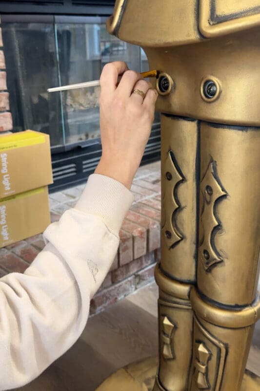 Hand brushing black Rub n Buff into the seams and screws on an antique bronze giant nutcracker to make the details pop.