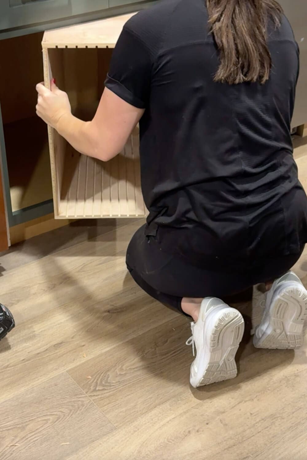 Sliding the finished plywood vertical storage box into the lower kitchen cabinet opening