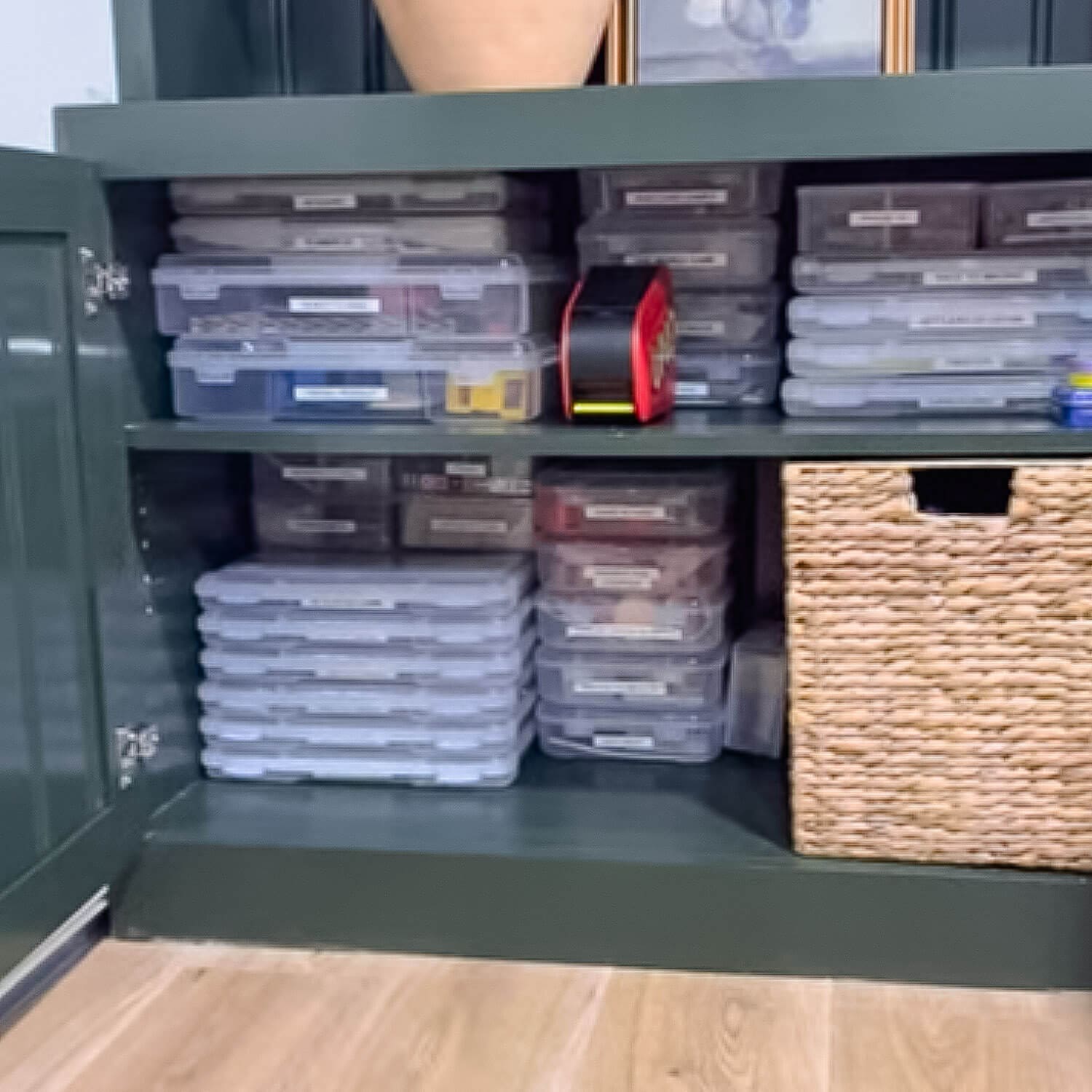 Board Game Storage Ideas showing labeled, matching plastic cases stacked neatly on cabinet shelves for easy board game and card game organization, plus a woven storage basket for extras.