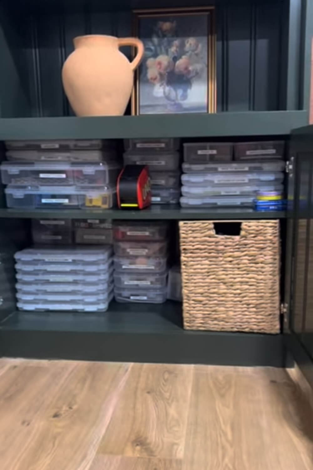 Board Game Storage Ideas inside a built-in cabinet using uniform, stackable clear containers labeled for board games and card games, with a woven basket bin on the bottom shelf.