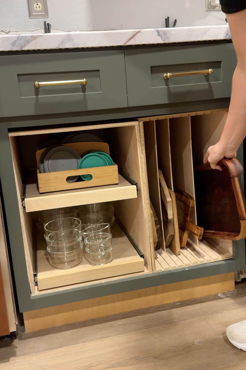 Custom pull-out cabinet storage with a vertical sheet pan and cutting board organizer, showing boards and trays stored upright for easy DIY clutter solutions.