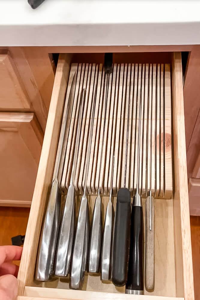DIY in-drawer knife block organizer with wood slots holding knives neatly inside a drawer for safe, clutter-free storage solutions.