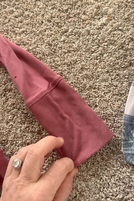 Close-up of a kids sweatshirt cuff after laundry stripping, showing smoother fabric and less residue after removing buildup and odors.