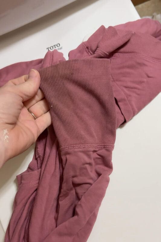 Close-up of a grimy kids sweatshirt sleeve showing heavy detergent buildup before deep cleaning to remove gross residue and trapped odors.