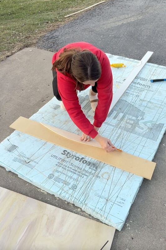 Tracing an arched curve on a trim board for creating arched trimwork that looks like box molding