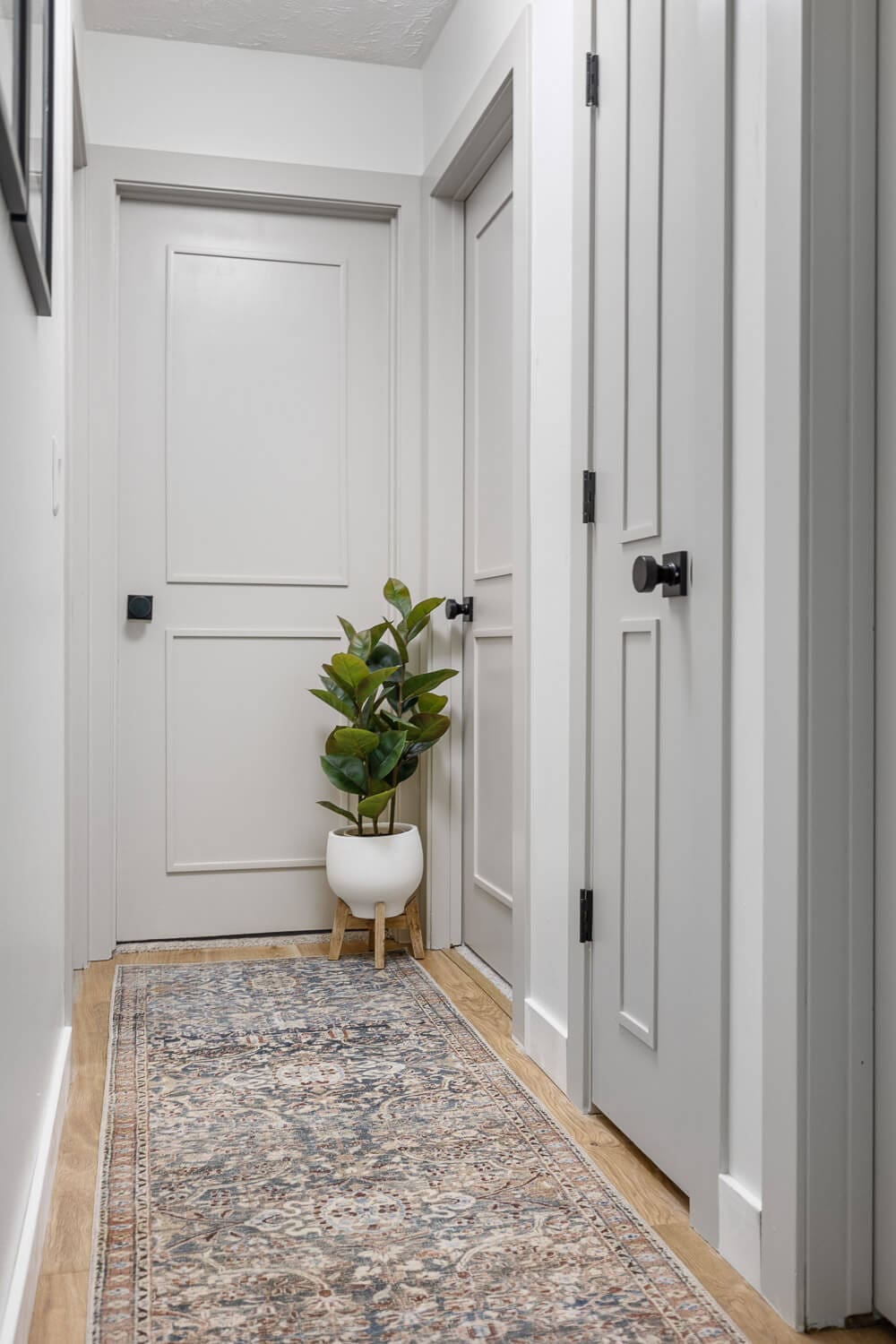 Finished hallway interior door upgrade with trim panels and black hardware