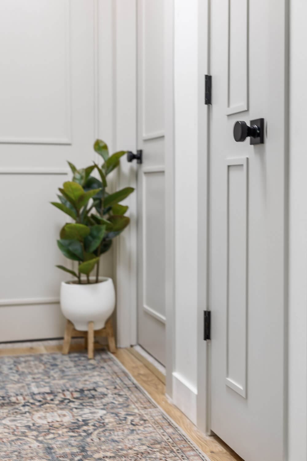 Finished hallway interior door upgrade with trim panels and black hardware
