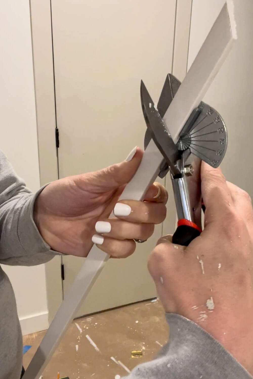 Cutting door trim at 45 degree angle with miter shears for DIY door upgrade