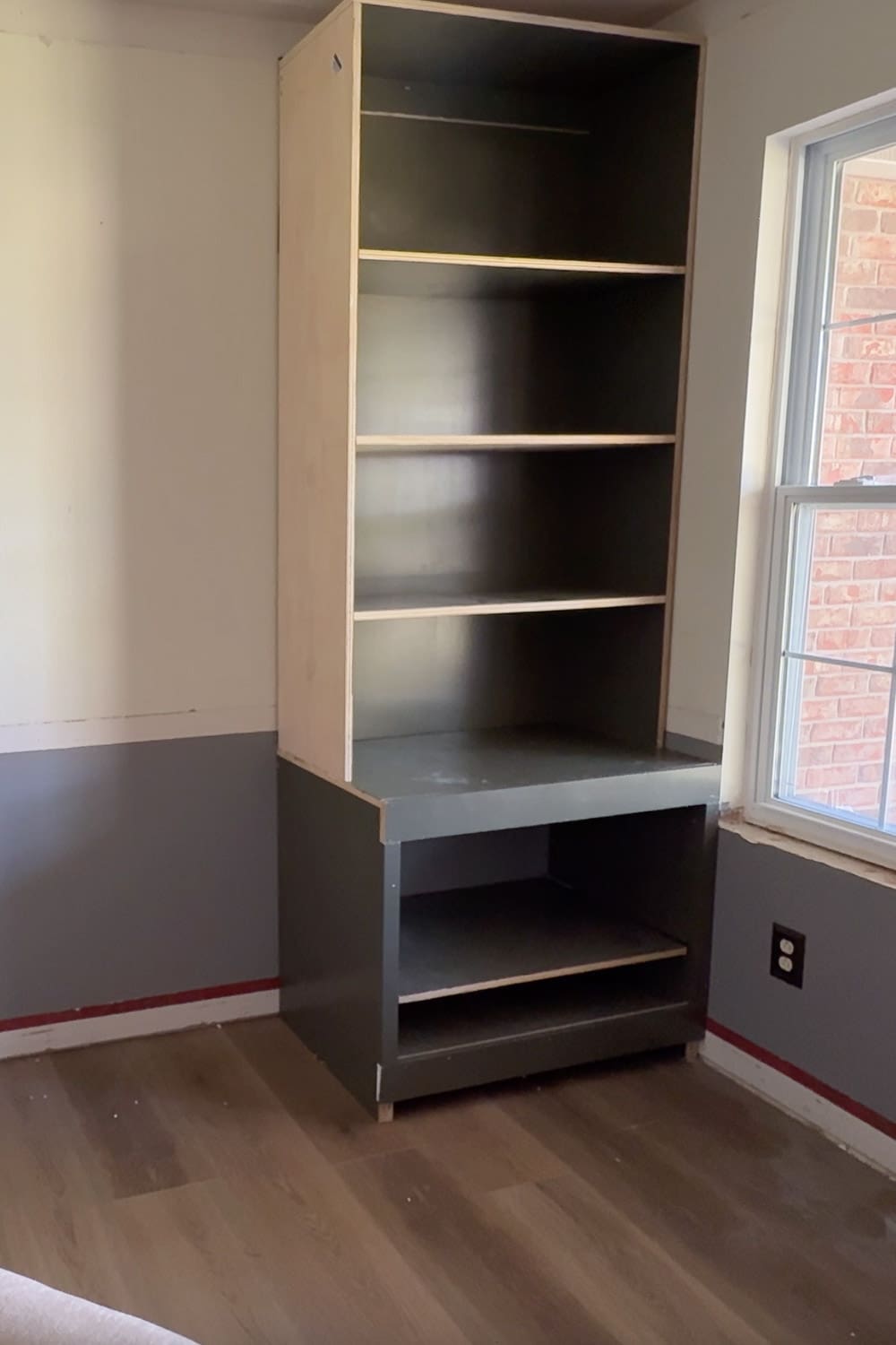 Finished view of stacked DIY home library bookshelves installed above a base cabinet, ready for trim and finishing.