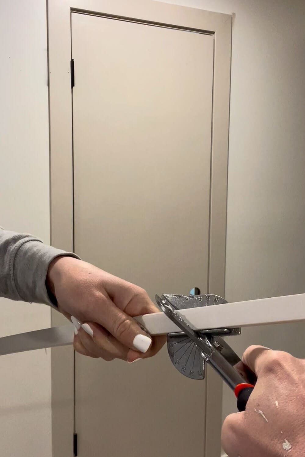 Cutting trim piece to size with miter shears for interior door makeover