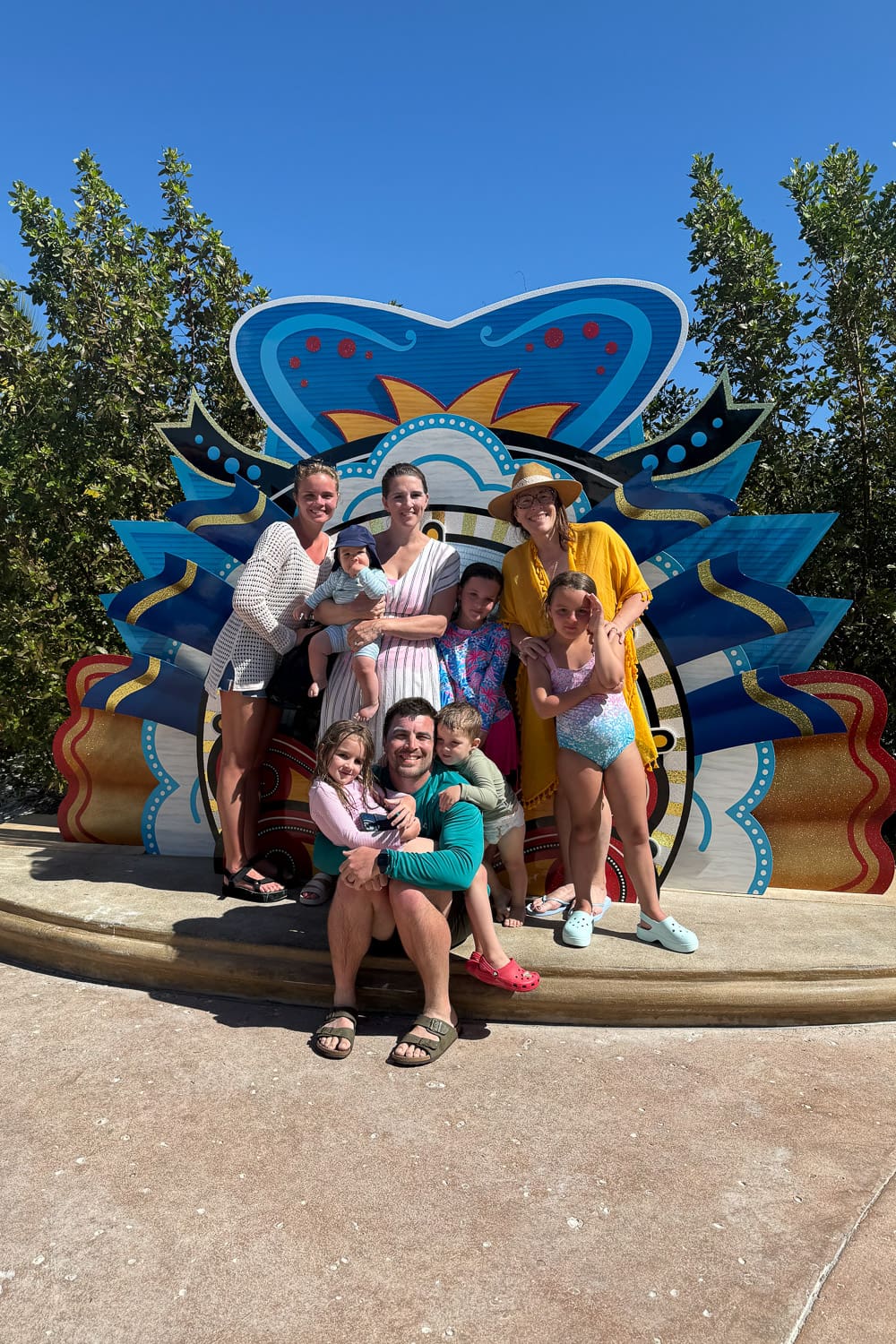 arge family with kids posing together at lookout cay lighthouse point on a disney cruise private island in the bahamas