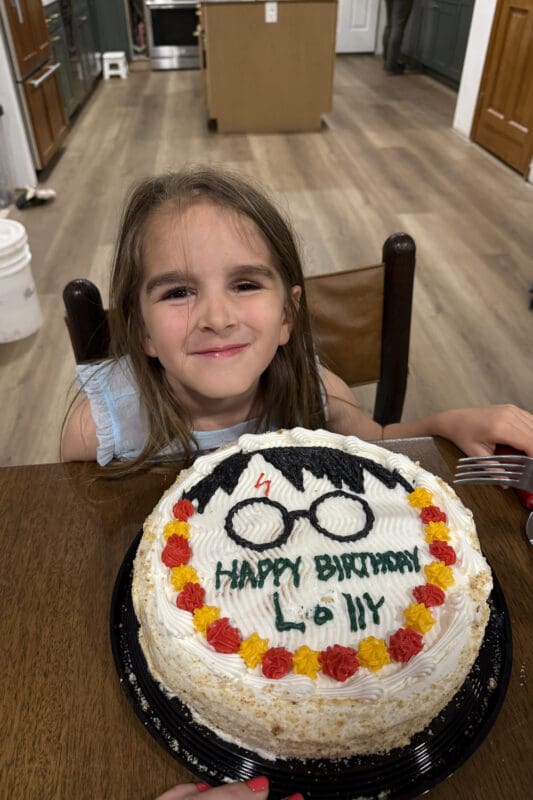 finished harry potter cake with glasses lightning bolt and happy birthday message on white frosting