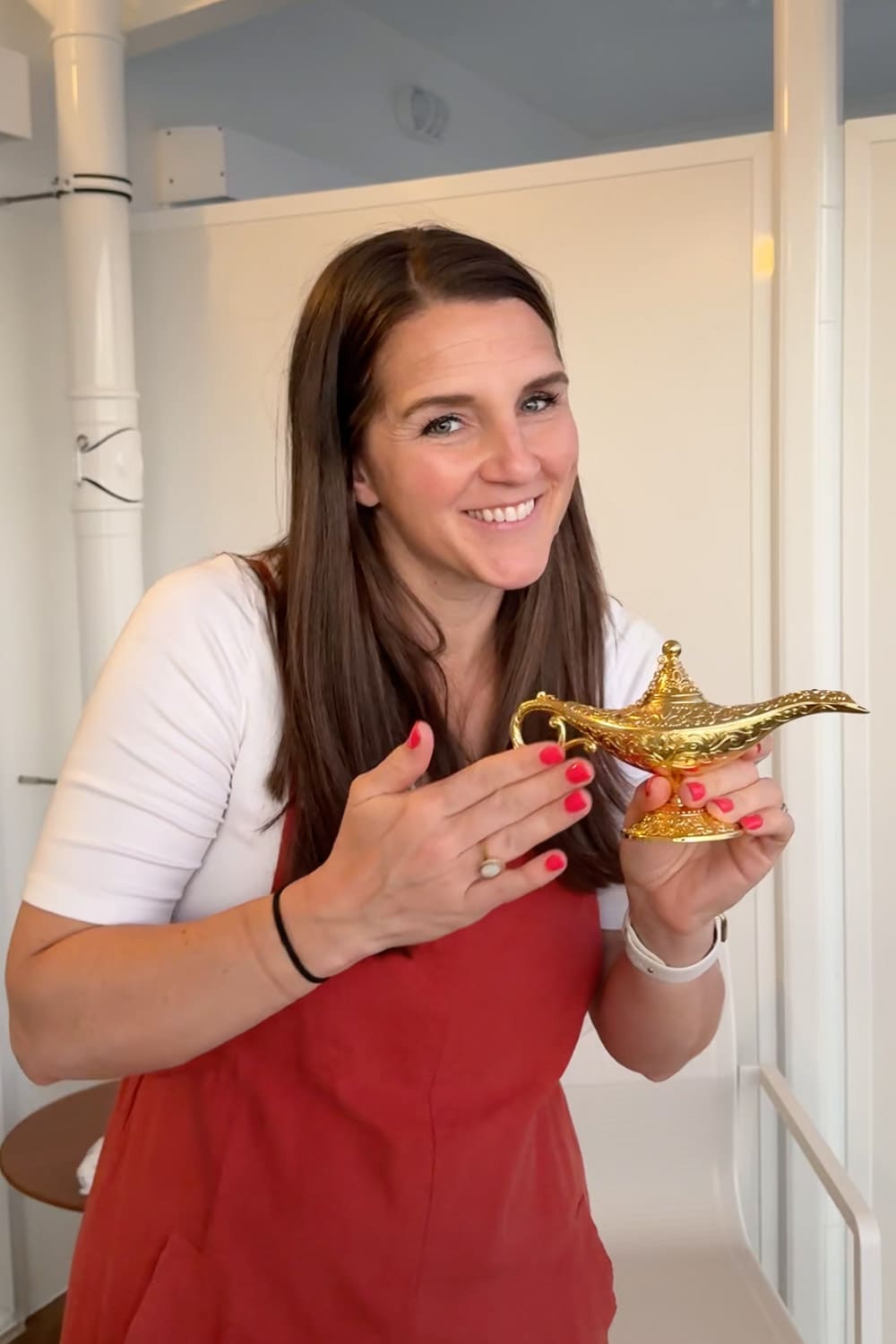 woman holding gold genie lamp used to surprise kids with disney trip using three wishes reveal idea