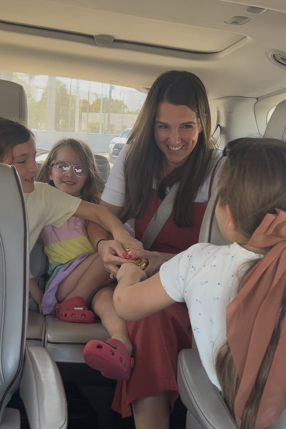 Mom holding genie lamp with kids in the car. 