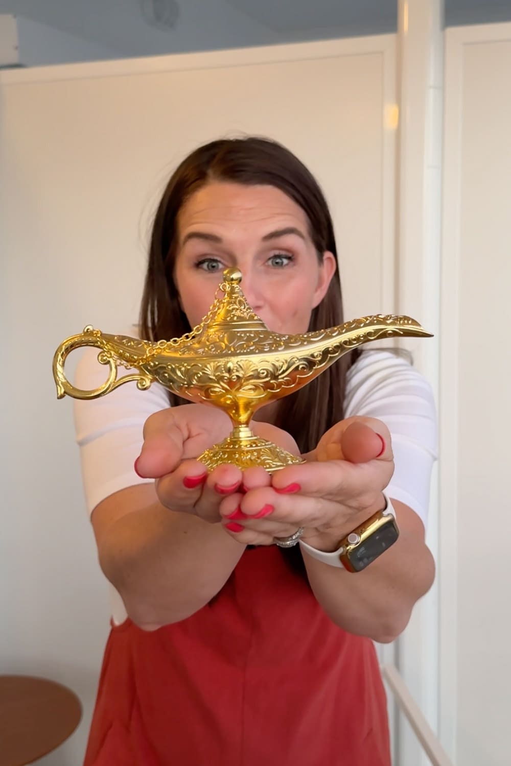 Mom holding genie lamp as part of how to surprise kids with a Disney trip using a fun three wishes reveal idea