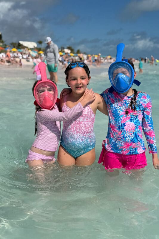 kids wearing full face snorkel masks playing in shallow ocean water at lookout cay lighthouse point during beach day