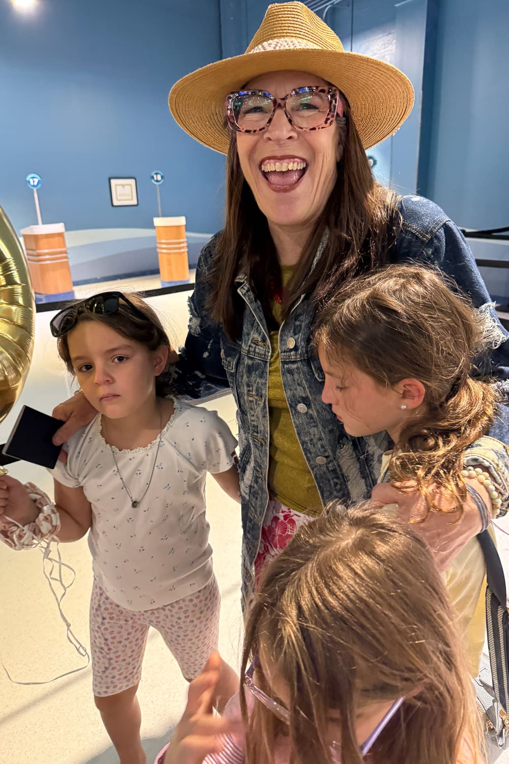 Grandma smiling and hugging grandkids getting ready to board a big family cruise
