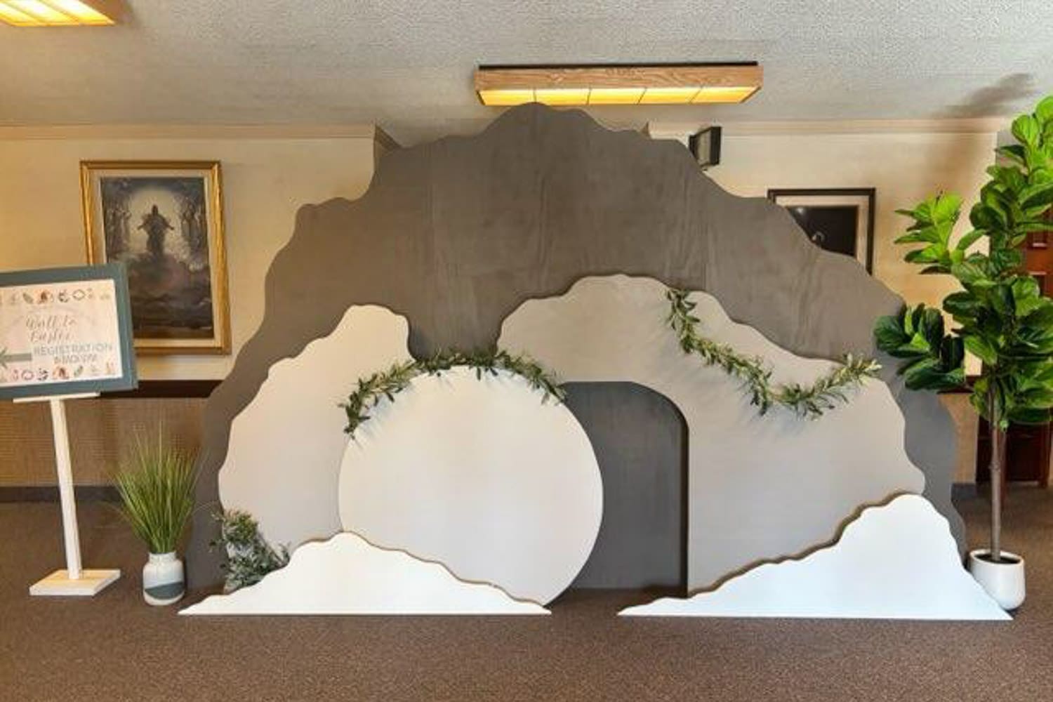 Walk to Easter Easter church activity for kids tomb scene with rolled stone, decorative greenery, and church hallway setup representing the resurrection