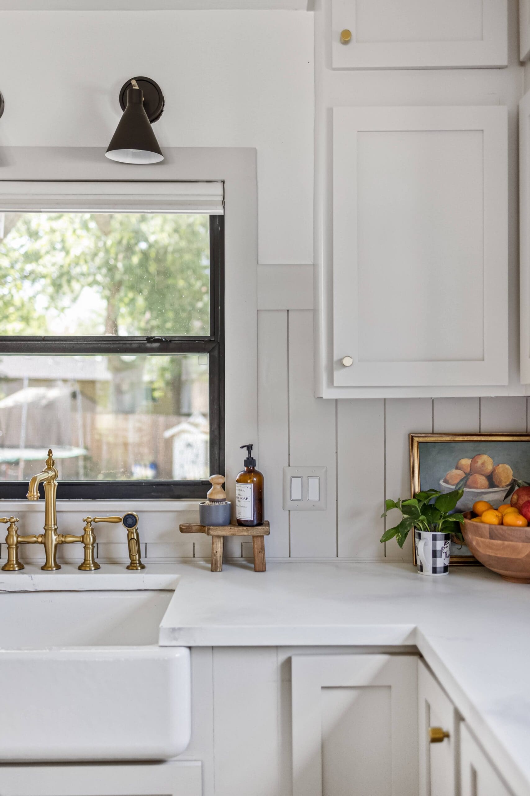 Sherwin Williams Accessible Beige on kitchen cabinets with white countertops and gold bridge faucet