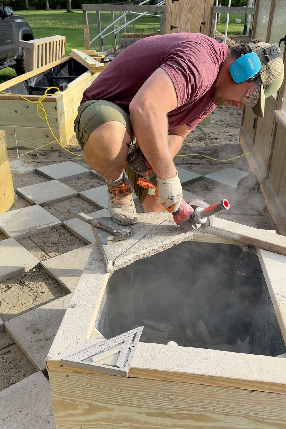 Cutting a concrete paver at a diagonal angle with an angle grinder and diamond blade to fit the edge of a diamond pattern walkway