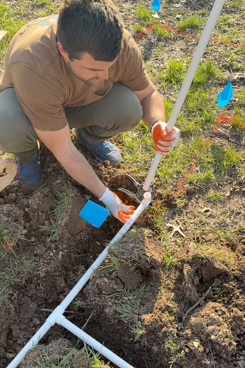 Cutting PVC pipe to size with a ratcheting cutter to install a vertical spigot riser for a DIY raised bed watering system