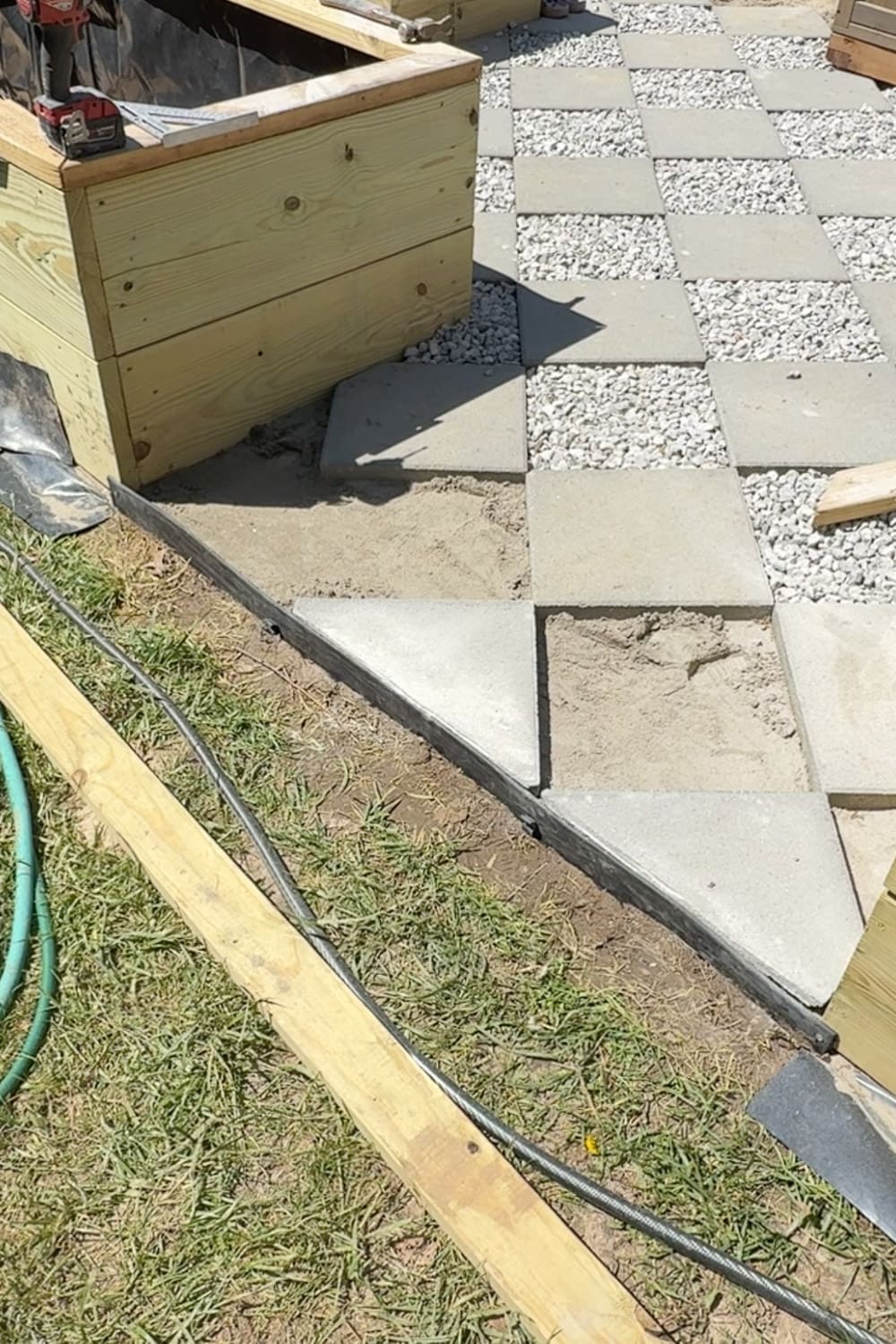 Diagonally cut pavers fitted neatly along the landscape edging at the corner of a DIY paver walkway with a diamond pattern