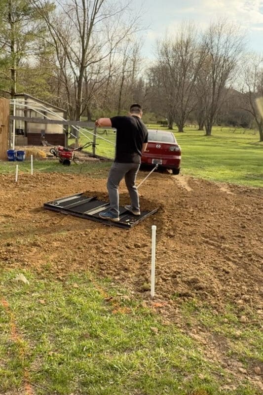 Trailer gate used as a DIY drag tool to flatten and level soil for raised garden beds