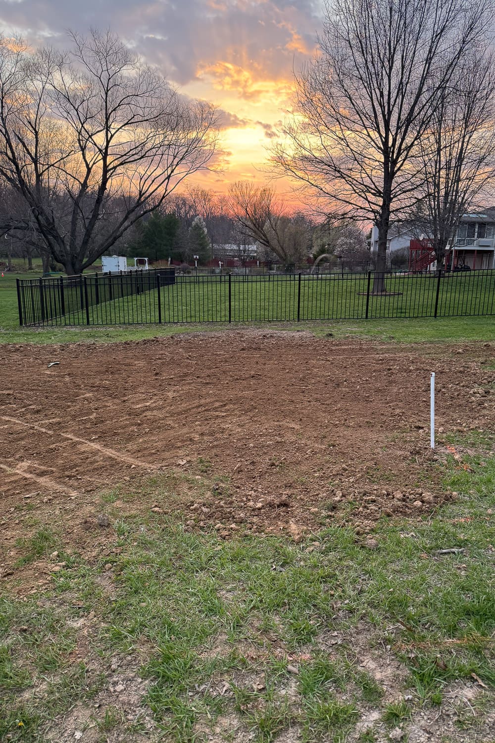 Leveled ground for garden beds after compacting soil with a plate compactor in backyard