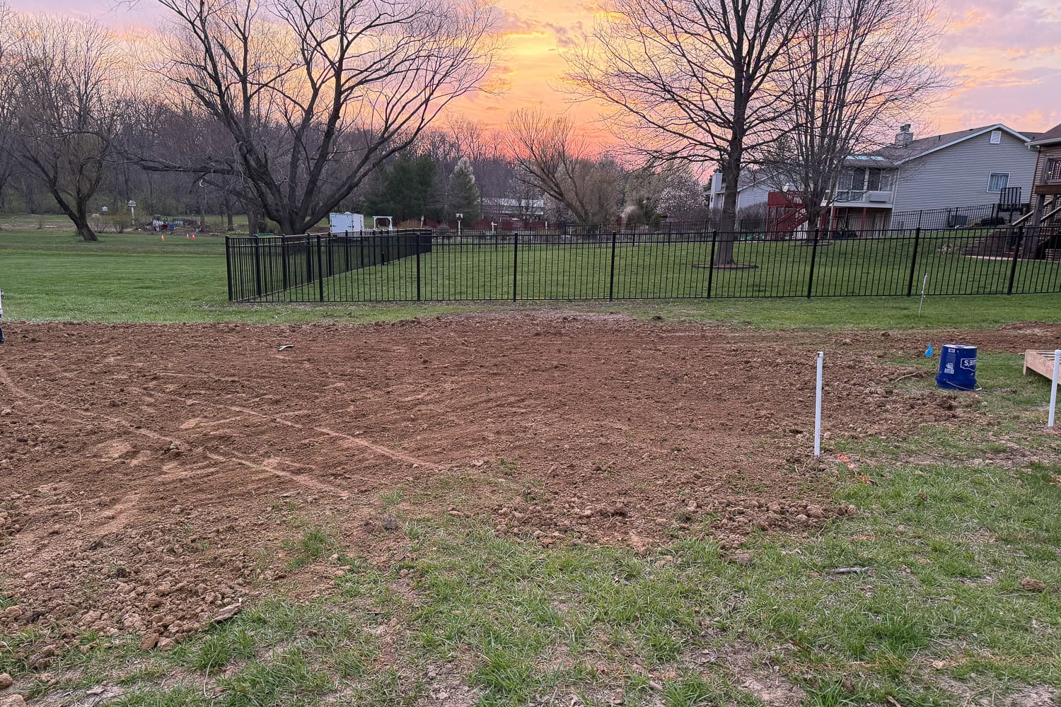 Fully leveled and compacted ground prepared for garden beds in backyard