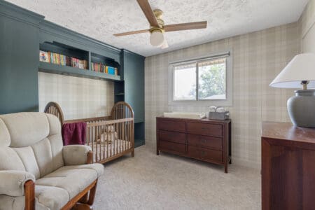 Sherwin Williams Mountain Pass on custom built-in bed surround in nursery with plaid wallpaper and wood crib