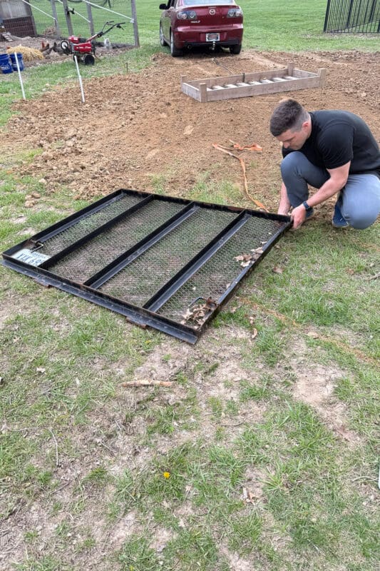 Using a trailer gate dragged behind a car to smooth fill dirt over an uneven yard.