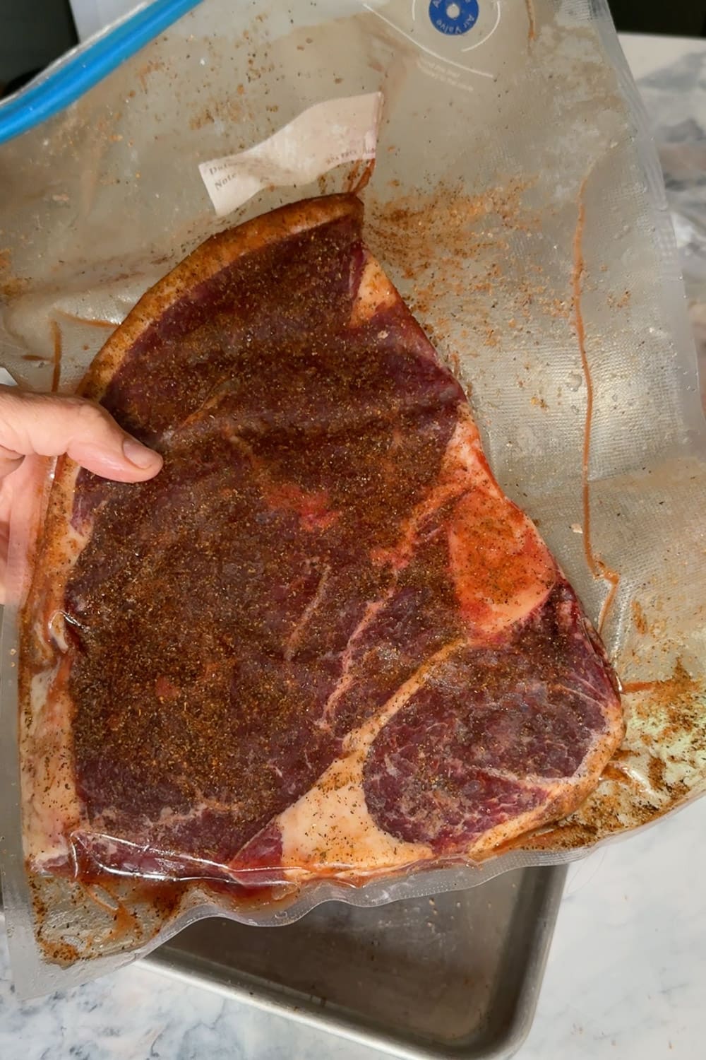 Seasoned bone-in steak rubbed with spices and sealed in a bag, ready to sous vide