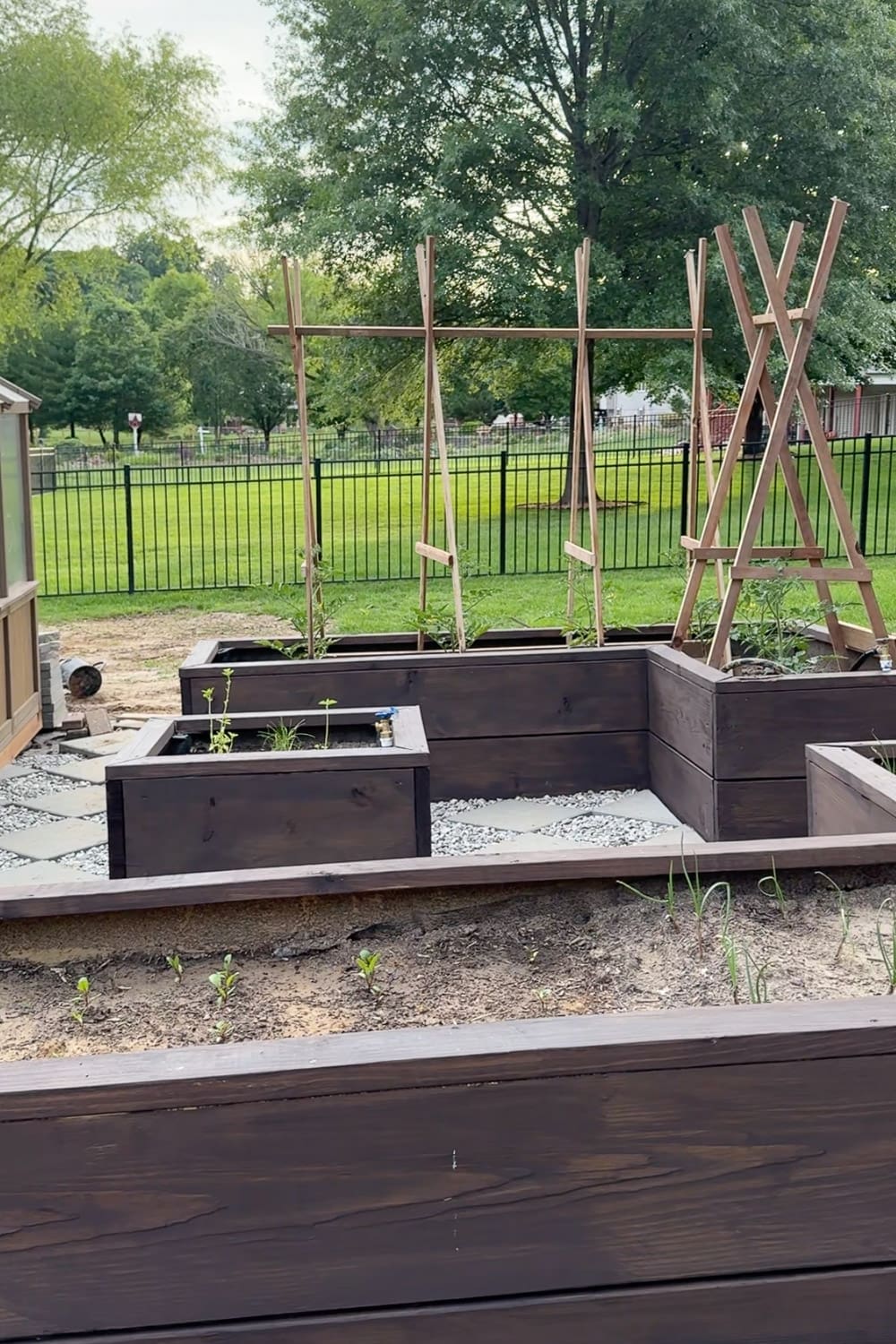 Completed DIY dark planters in a U-shaped layout with trellises and seating edge