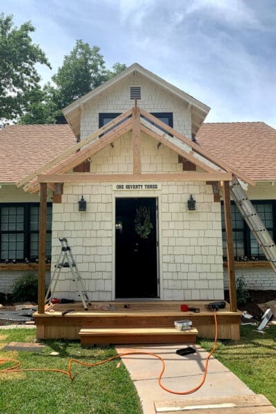 gable porch roof framing with rafters and angled braces before sheathing