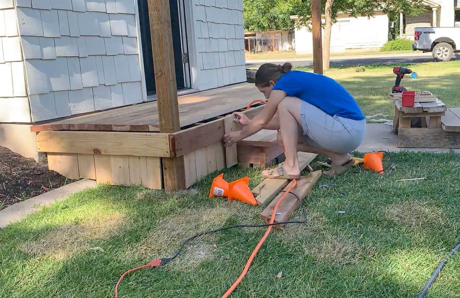 Crystel marking and fastening a skirt board along the front of the porch and box step.