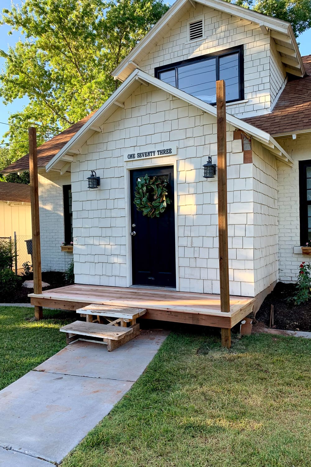 DIY front porch with the deck boards installed and temporary wooden steps in place before the permanent porch step was built.