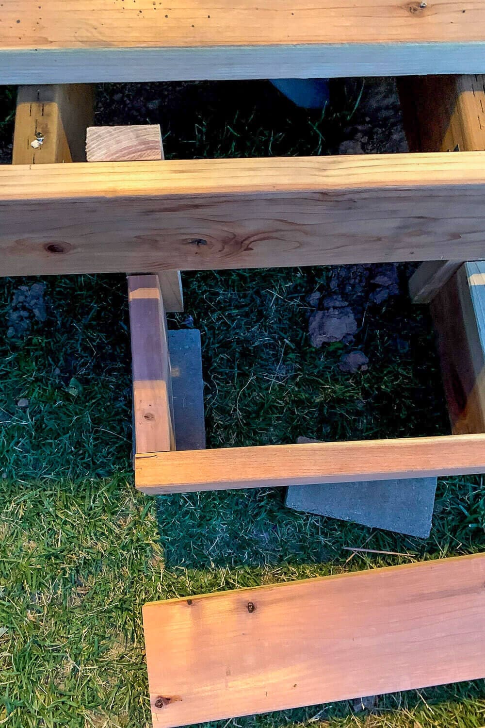 Top-down view of the box step frame with evenly spaced cross supports sitting on a paver footing.