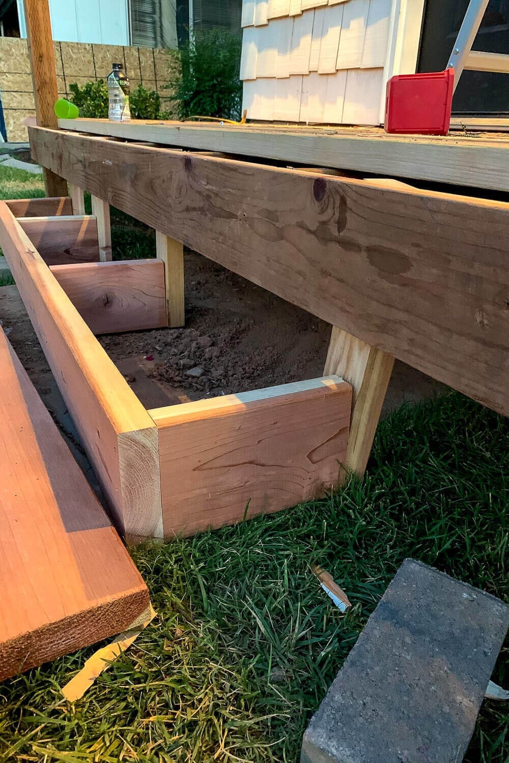 Box step frame with cross supports positioned on footings in front of the open porch base before the treads go on.