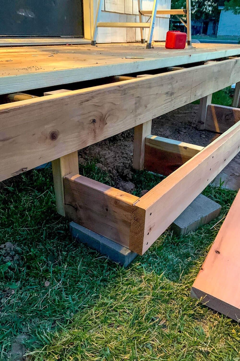 Box step frame set on a cinder block footing and screwed tight against the porch frame.