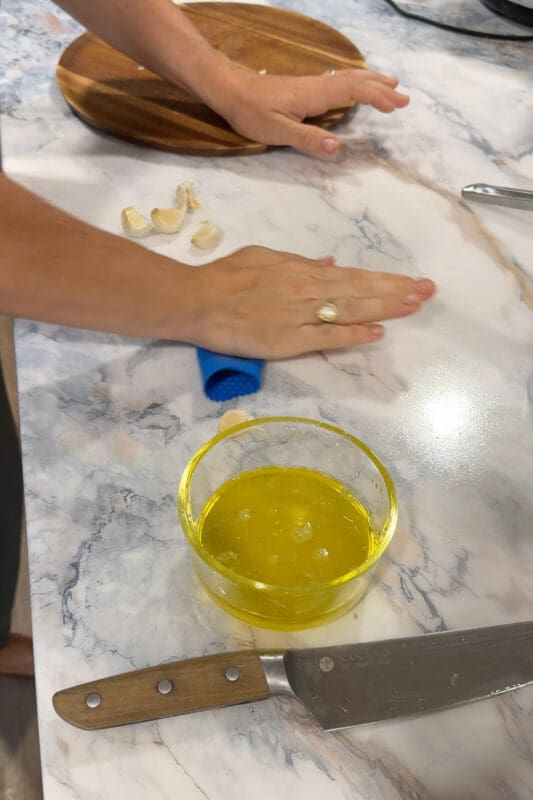 Crystel using a blue silicone garlic roller to peel cloves of garlic the fastest way