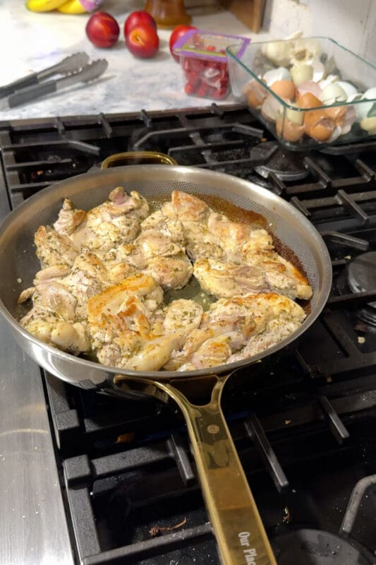 Golden seared lemon-oregano chicken thighs cooking in the pan for Greek lemon chicken rice bowls