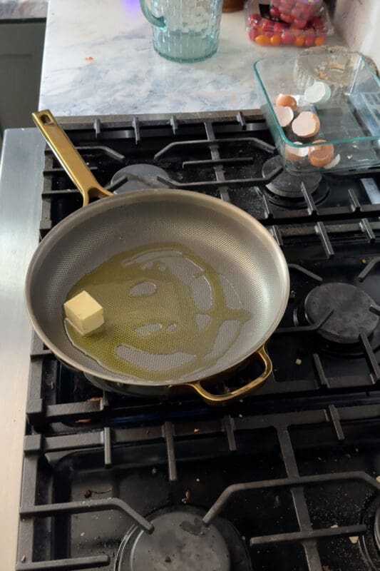 Crystel melting a pat of butter with olive oil in a stainless steel pan on the stovetop.