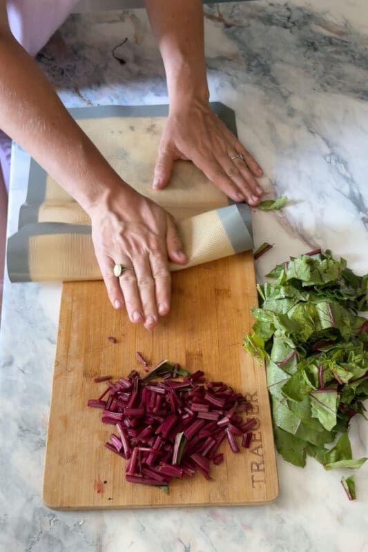Crystel rolling a silicone mat to loosen garlic peels.