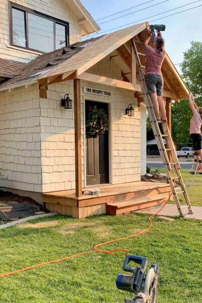 Nailing OSB panels onto the porch roof rafters with a framing nailer