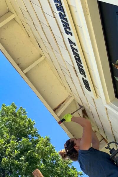 Step 1 of how to build a porch roof: removing soffit and shingles to expose house framing