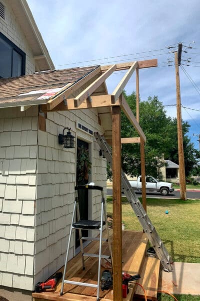 Installing rafters into ridge board during porch roof frame construction